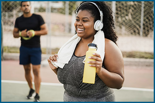 woman smiling outside while exercising