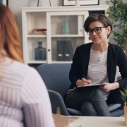 A woman sitting in a chair talking to another woman